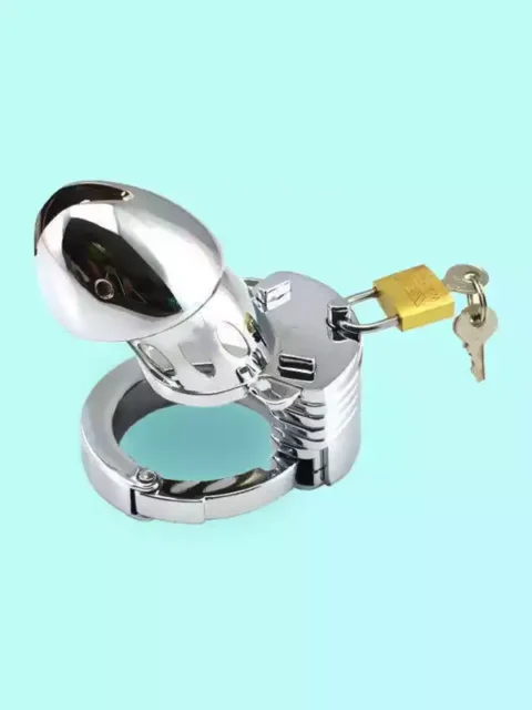 A polished chrome metal male chastity cage with a hinged base ring, secured with a brass padlock and keys, isolated against a light teal background.